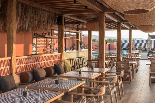a restaurant with wooden tables and chairs on a patio at The Syntopia Hotel - Adults Only in Adelianos Kampos