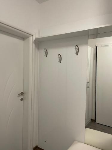 een witte kamer met een spiegel en een deur bij Ilia’s Guesthouse in Pogradec