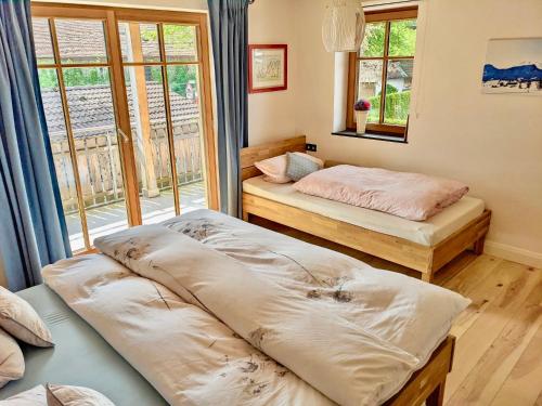 two beds sitting in a room with a window at Haus Sonnenau in Pfronten