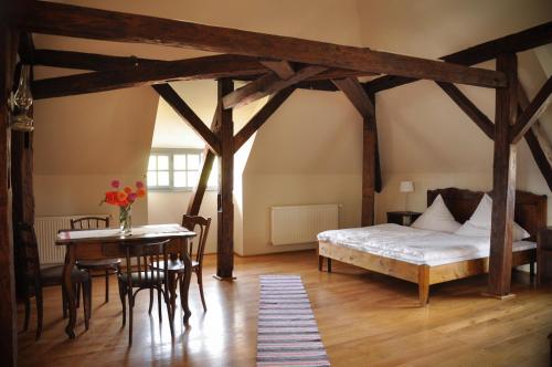 a bedroom with a bed and a table and a tableablish at Transylvania Guesthouses in Cincşor
