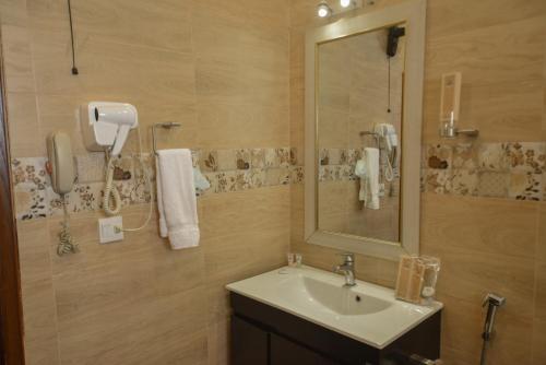 bagno con lavandino e specchio di Swisstel Cottage a Karachi