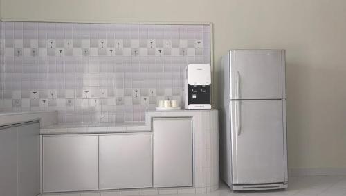 a kitchen with a refrigerator and a coffee maker at Mersing Spacious 3bedroom with free parking space in Mersing