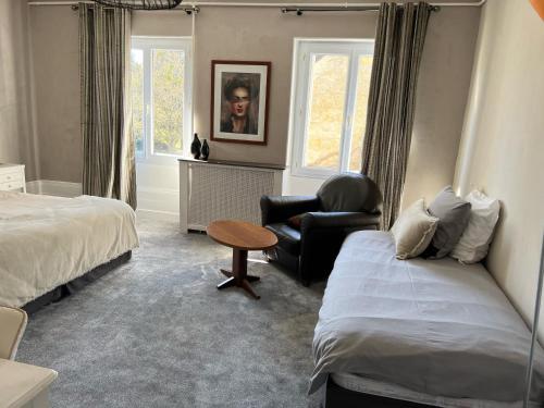 a hotel room with a bed and a chair and a table at Chambres d'hôtes & Spa Les Perce Neige in Vernou-sur-Brenne