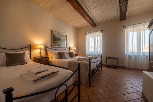 a bedroom with two beds and two tables in it at CONVINO in Castiglione Falletto
