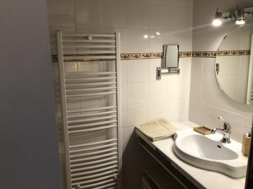 ein weißes Badezimmer mit einem Waschbecken und einem Spiegel in der Unterkunft Magnifique Gîte en provence in Sarrians