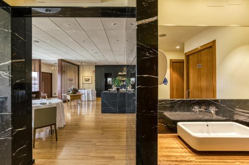 um átrio do hotel com um lavatório e uma mesa em Hotel Emporium - Adults Only em Castelló d'Empúries
