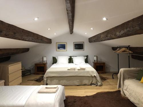 een slaapkamer met 2 bedden in een kamer met balken bij Magnifique Gîte en provence in Sarrians