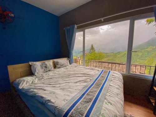 a bed in a room with a large window at Catcat Garden House in Sa Pa