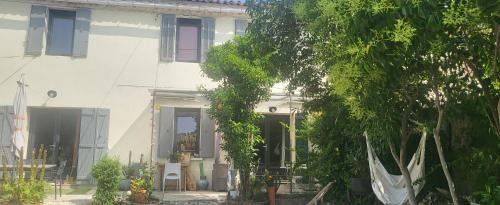 ein weißes Haus mit einem Baum davor in der Unterkunft Studette indépendante et coquette avec terrasse sur jardin in Marseille