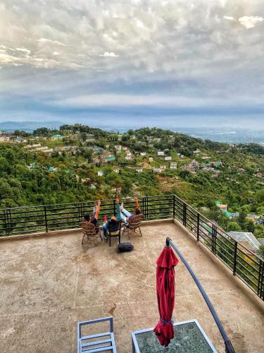 a group of people sitting in chairs on a balcony at Redeem Cafe & Homestay in McLeod Ganj