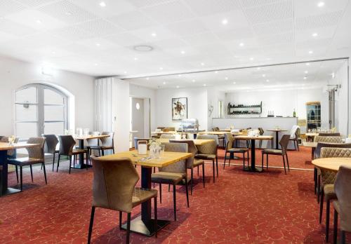 Hotel Søparken في Åbybro: مطعم فيه طاولات وكراسي في الغرفة