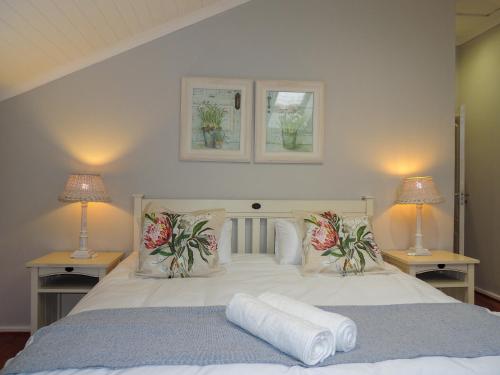 a bedroom with a white bed with two lamps at 7 @ The Dunes in Plettenberg Bay