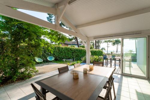 d'une terrasse avec une table et des chaises en bois. dans l'établissement Villa Marie - Pyla sur mer superbe villa 10 personnes vue Bassin, à La Teste-de-Buch