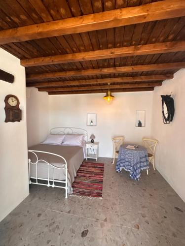 Rizes Mykonos - Folklore Farmstead في مدينة ميكونوس: غرفة نوم في بيت فيه سرير وطاولة