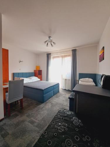 a bedroom with two beds and a desk and a table at Willa Kwiatano - Plac zabaw & Jacuzzi & Basen & Sauna - Budynek C in Grzybowo