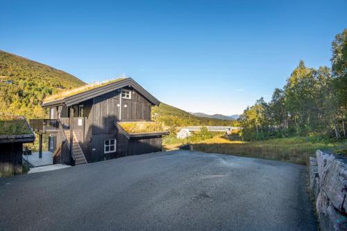 a house on a road with a barn at Penthouse apartment at Strandafjellet in Stranda