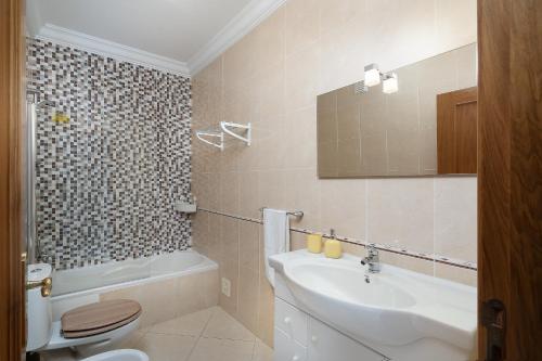 a bathroom with a sink and a toilet and a sink at IsaBela Holidays in Olhos de Água