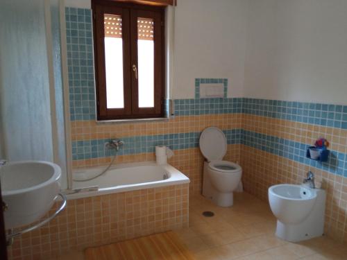 a bathroom with a tub and a toilet and a sink at Next stop Paestum in Paestum