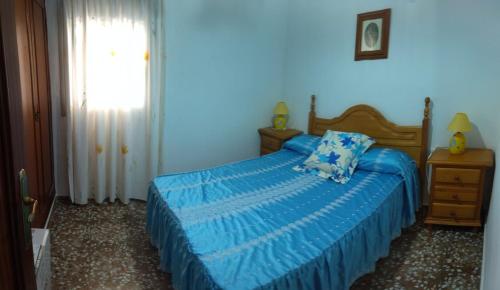 a blue bedroom with a bed and a window at Casa rural la casa del Conde in Puebla de la Parrilla