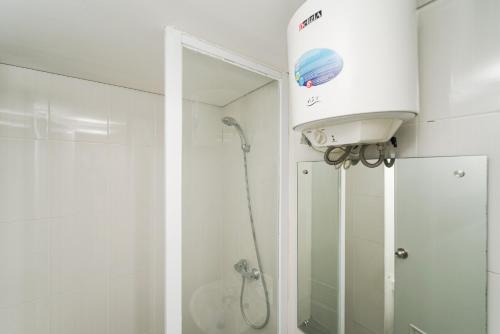 a bathroom with a shower and a shower head at RedLiving Apartemen 19 Avenue - Reza Property in Porisgaga
