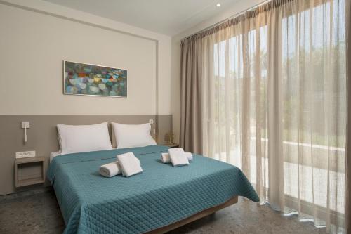 a bedroom with a bed and a large window at Ethereal Villas Chania in Daratso