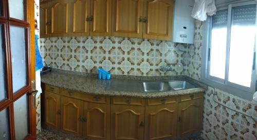 a kitchen with wooden cabinets and a sink at Casa rural la casa del Conde in Puebla de la Parrilla