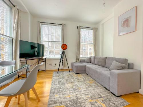 sala de estar con sofá y TV de pantalla plana en Gower street residences en Londres