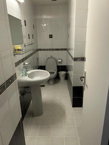 a bathroom with a white sink and a toilet at Abu Dhabi Downtown 3 bedroom Penthouse Apartment in Abu Dhabi