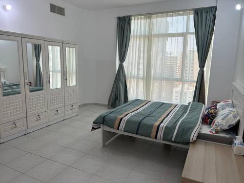 a bedroom with a bed and a large window at Abu Dhabi Downtown 3 bedroom Penthouse Apartment in Abu Dhabi
