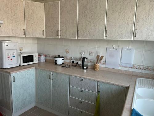 a kitchen with a counter with a microwave and appliances at Abu Dhabi Downtown 3 bedroom Penthouse Apartment in Abu Dhabi