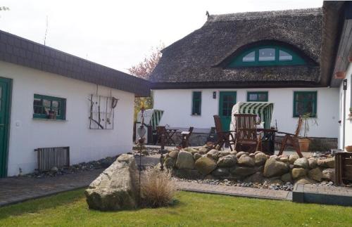 een huis met een tuin met stoelen en een rotswand bij Haus Ostseerose - Ferienwohnungen Florentine, Linus, Ostseerose in Hagen