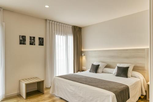 a bedroom with a large bed and a window at Hotel Emporium - Adults Only in Castelló d'Empúries
