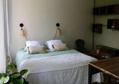 een slaapkamer met een bed met 2 kussens erop bij BEAU STUDIO DANS VILLA DE CHARME in Saint-Laurent-de-Brévedent
