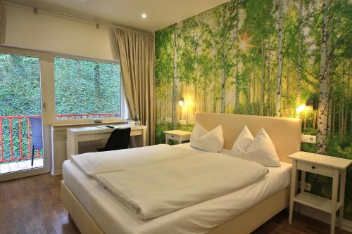 een slaapkamer met een groot bed met een groene muur bij Landidyll Hotel Weidenbrück & SPA in Swisttal