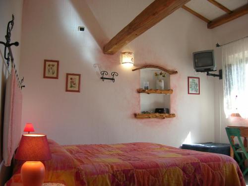a bedroom with a bed and a tv in a room at La MeSenda Rooms & Apartments in Arzachena