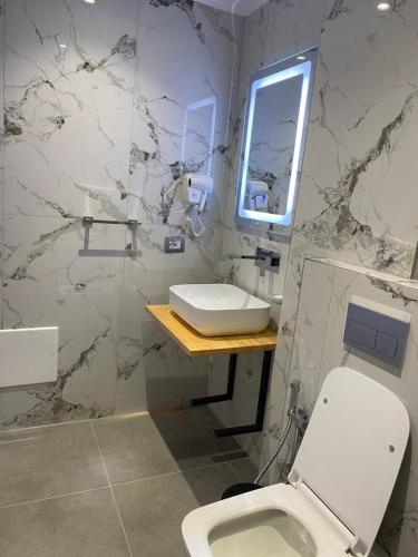 a bathroom with a white toilet and a sink at Sea's Villa in Ksamil