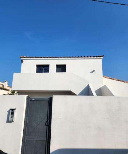 a white building with a black door on it at appartement 40 m 2 in Pérols