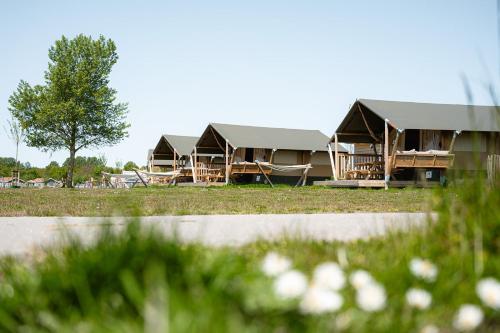 a row of luxury lodges in a field at Glamping Schotsman in Kamperland