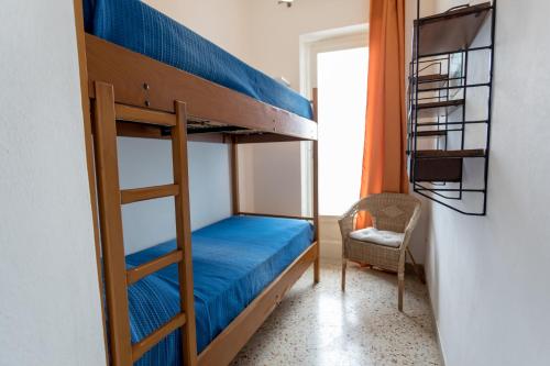 a bunk bed in a room with a desk and a chair at Appartamento Selinunte in Marinella di Selinunte