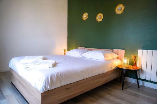 - un lit avec des draps blancs et 2 miroirs sur le mur dans l'établissement L'Eden Urbain・Stationnement Facile・Proche Centre, à Châteauroux