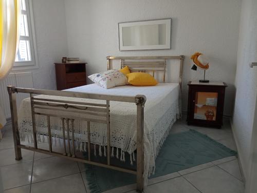 Un dormitorio con una cama con almohadas amarillas. en Villa Danai, en Toroni