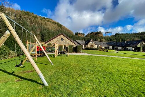 a park with a swing set in a field at Melfort Village in Oban