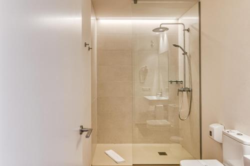 a shower with a glass door in a bathroom at Hotel Emporium - Adults Only in Castelló d'Empúries