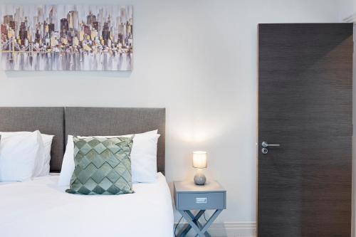 una camera con letto e tavolo con lampada di Spacious, 3 bedroom, 2 bathroom, Surbiton a Surbiton