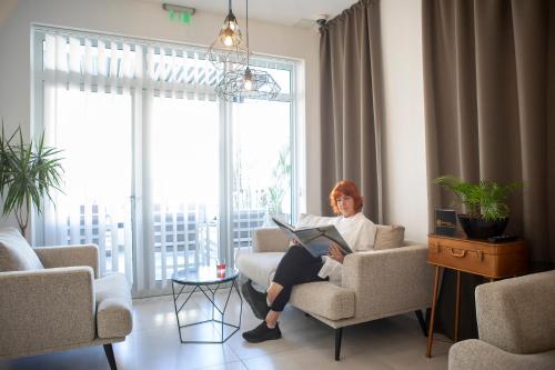 a woman sitting in a chair with a laptop at Boutique Hotel Intermezzo - Pag centre in Pag