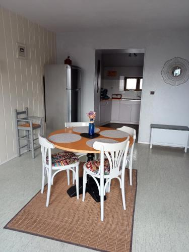 a kitchen with a table and chairs and a refrigerator at Gîte du Kreizker in Cléden-Poher