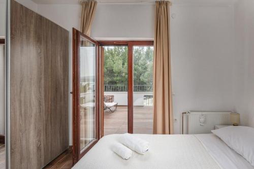 a bedroom with a bed and a view of a balcony at Apartments Hablando in Pridraga