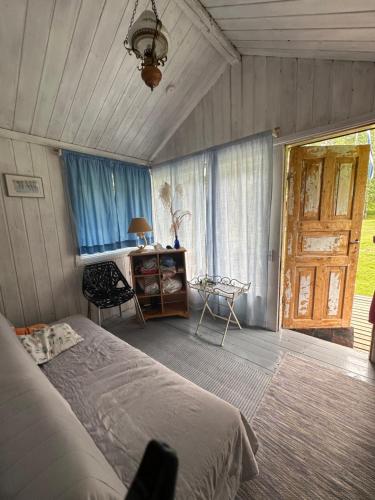 Schlafzimmer mit einem Bett, einem Schreibtisch und einem Fenster in der Unterkunft Teeveere kämping in Treimani