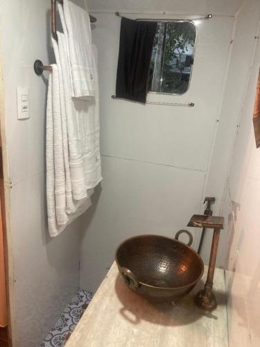 a bathroom with a copper bowl on a counter at Salamandra trailerhome in Pirenópolis