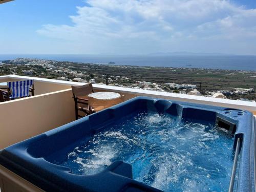 bañera de hidromasaje en el balcón con vistas al océano en Panorama Oia Apartments, en Oia